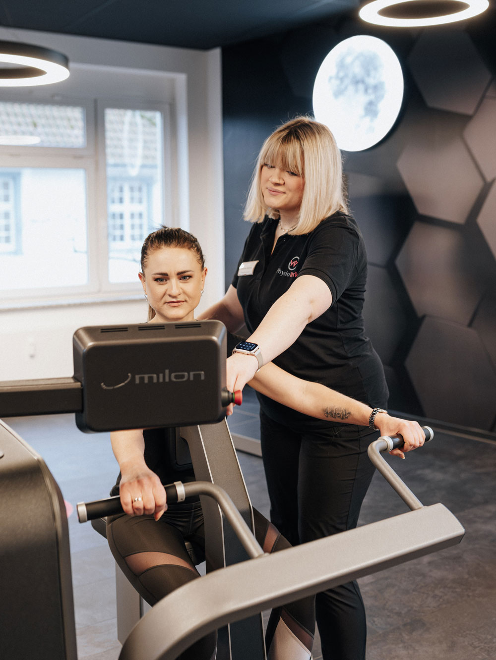 Physiotherapeutin und Patient bei der Krankengymnastik