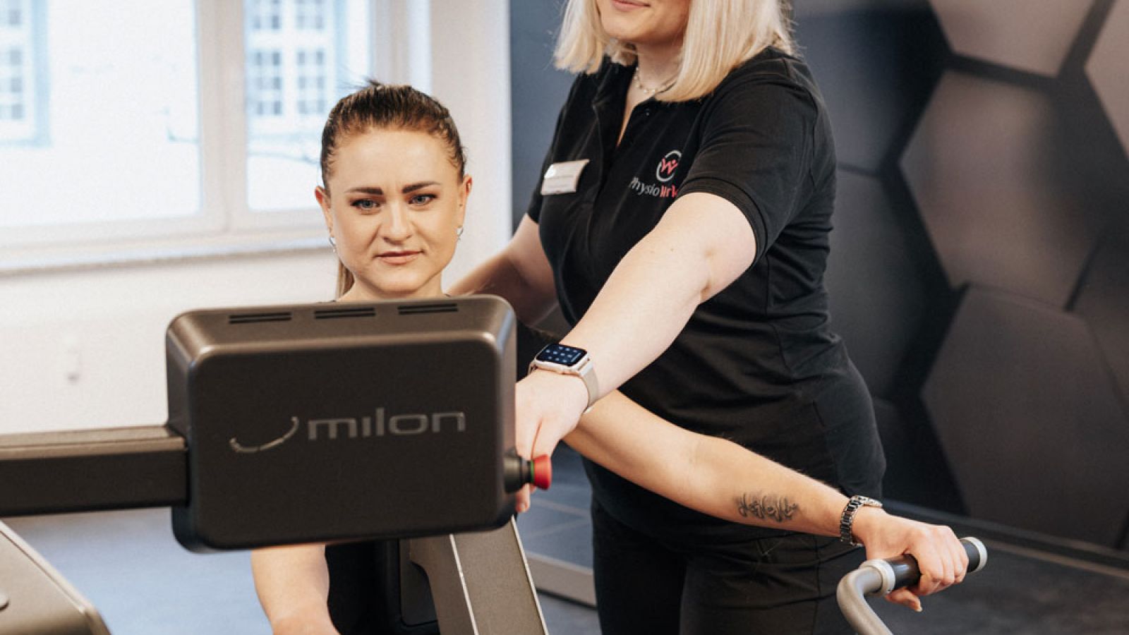 Physiotherapeutin und Patient bei der Krankengymnastik